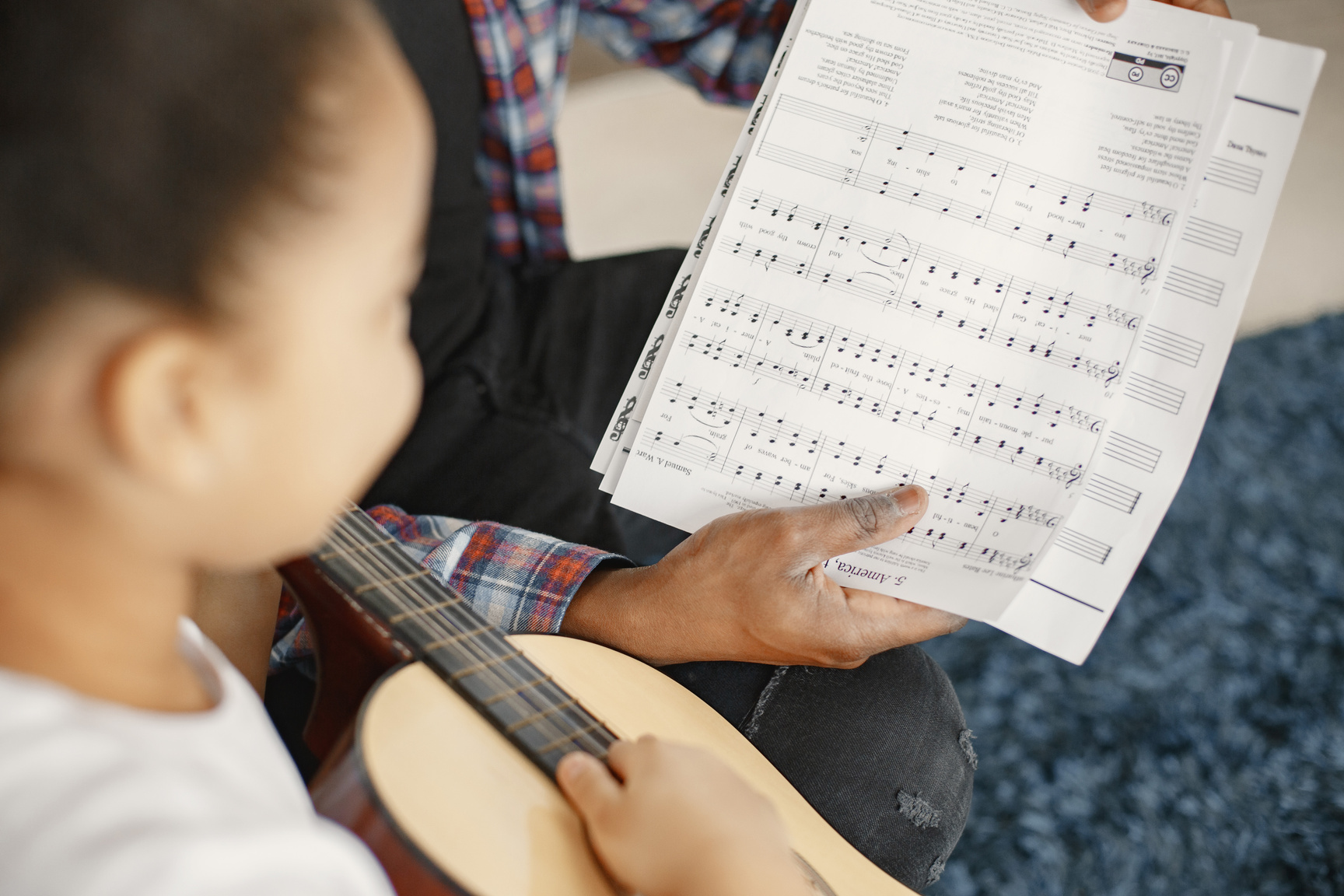 Girl with Guitar Looking at Music Sheet